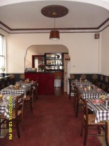 un comedor con mesas y sillas y un bar en Thorpe Lodge Hotel en Peterborough