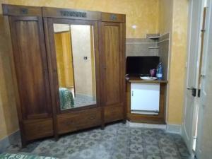 a room with a large wooden cabinet with a mirror at Palazzo Spiga in Quartu SantʼElena