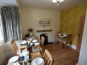 a dining room with a table and a fireplace at Romsey Brewery House - circa 1893 in Romsey