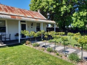 a garden in front of a house with trees at Yallamatta Bed and Breakfast in Apsley