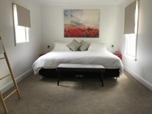 a bedroom with a bed with a painting on the wall at Yallamatta Bed and Breakfast in Apsley