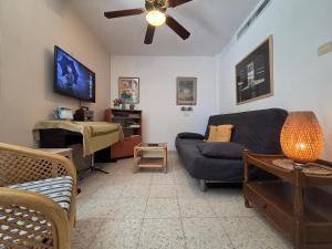 a living room with a couch and a ceiling fan at Like home at the Tehar-Lev family in Eilat +22 photos