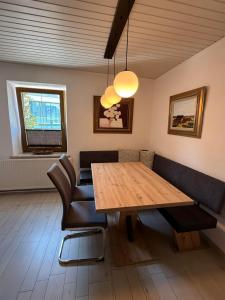 a dining room with a wooden table and chairs at Ferienwohnung Steinlicht in Lienz