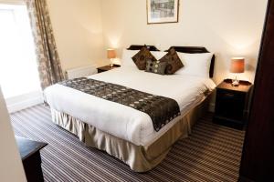 a bedroom with a large white bed with two lamps at Munster Arms Hotel in Bandon