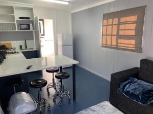 a kitchen with a counter and stools in a room at Sundays River Tiny homes - 5 min from Addo Park South Gate in Gqeberha