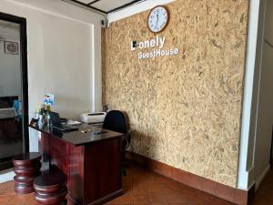 an office with a desk and a clock on a wall at Lonely Guesthouse in Luang Prabang
