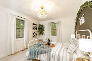 a white bedroom with a bed with a plant on it at Modern Mountain Retreat in Gatlinburg