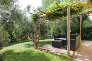 a couch sitting under a pergola in a yard at Villa Oliva in Canino