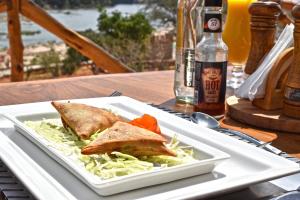 un plato blanco con un sándwich y verduras en una mesa en Kiboko River Camp, en Koito