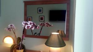a room with a mirror and a lamp and flowers at Guest House Tonica in Krk