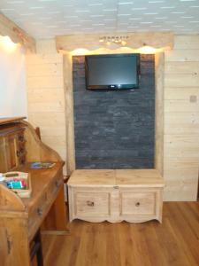 a room with a tv on a brick wall at Chambres d'hôtes le génépi in Valdeblore