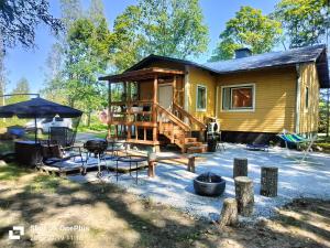 a tiny house with a porch and a deck at Retro House in Savonlinna