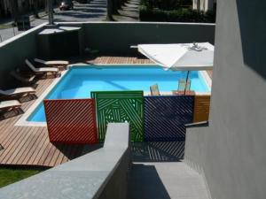 盧卡的住宿－聖馬可度假酒店，一个带桌子和遮阳伞的游泳池
