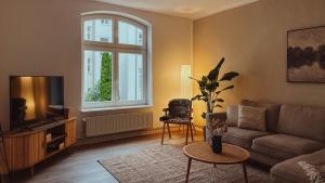 a living room with a couch and a tv at Nordisches Premium Apartment in Wismar