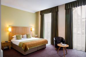 a hotel room with a bed and a chair at Walton Hall Hotel & Spa by Sunday in Wellesbourne Hastings
