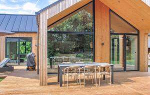 a patio with a table and chairs on a wooden deck at Cozy Home In Glesborg With Sauna in Glesborg