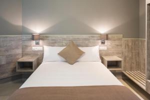 1 dormitorio con 1 cama grande y 2 mesitas de noche en Hotel Liberty Self Check-In, en Bellinzona