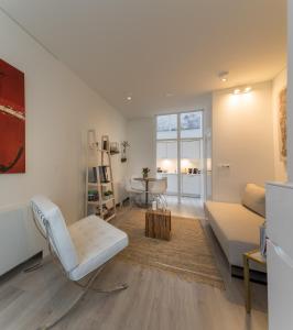 uma sala de estar com um sofá branco e uma mesa em Luxury Flower Market Apartment em Amsterdã