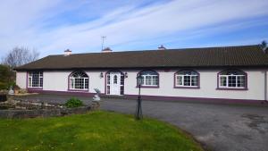 a white house with a black roof at Ponderosa B&B in Louisburgh