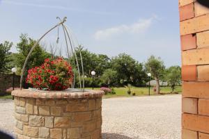 a stone wall with a flower pot in a park at Country House Il Melograno in Castellabate