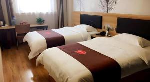 Cette chambre comprend 3 lits et un bureau. dans l'établissement Thank Inn Plus Hotel Shandong Jining High-tech District Huangtun Plaza Commercial Building, à Louzhuang 7 autres photos