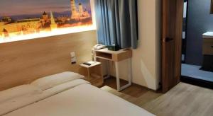 a hotel room with a bed and a television at London Hotel in Macau