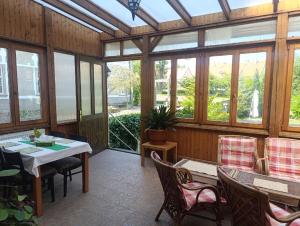 a conservatory with a table and chairs and windows at Penzion SIESTA in Příbor