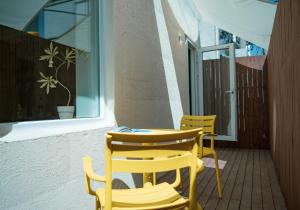 two yellow chairs and a table on a patio at Yeobaek Hotel in Incheon