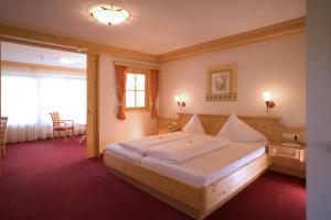 A bed or beds in a room at Hotel Alpenpanorama