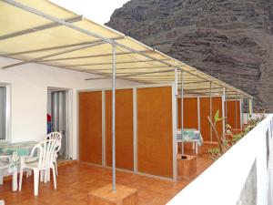 awning over a patio with a table and chairs at Apartamentos Domínguez in Calera