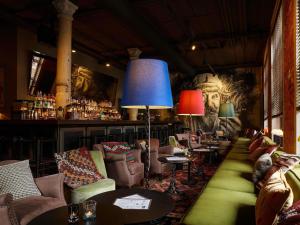 a restaurant with couches and tables and a bar at 25hours Hotel Hamburg HafenCity in Hamburg