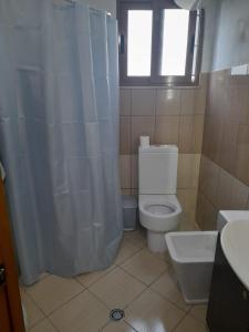 a bathroom with a toilet and a sink and a window at Hidden Gem Vlora in Vlorë