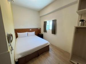 a bedroom with a white bed in a room at 又一宿-又上的臨時客棧 in Taitung City