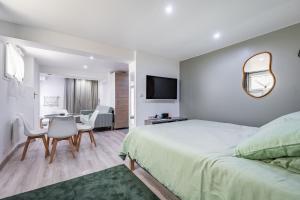 LarueにあるCasptay Chevilly-Larue - proche aéroport Orlyのベッドとテーブルと椅子のある寝室