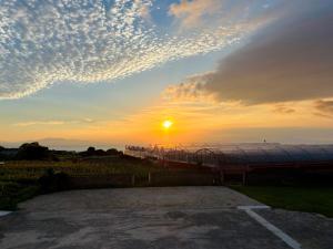 a sunset with the sun setting behind a roller coaster at ブラボーワールド in Shimabara
