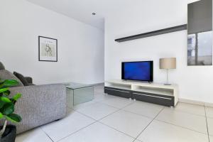 a living room with a tv and a couch at Tonis City Apartments in St Julian's