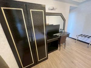 a room with a desk and a large black refrigerator at 又一宿-又上的臨時客棧 in Taitung City