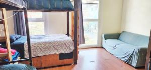 a bedroom with a bunk bed and a couch at La Casa Piola in Valparaíso +30 photos
