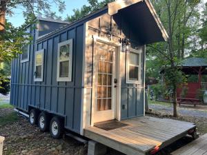 a blue tiny house sitting on a trailer at Hiker's Hideaway on The River in Cosby