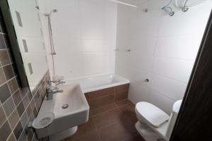 a bathroom with a sink and a toilet and a tub at Tonis City Apartments in St Julian's +26 photos