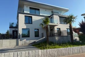 a white house with palm trees in front of it at Wohnung in Dahme