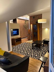 a living room with a couch and a tv at Apartament Rodzinny Huberta in Gdańsk