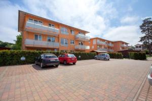 two cars parked in a parking lot in front of a building at Wohnung 4 Am Sportplatz &Uuml;ckeritz in Ueckeritz