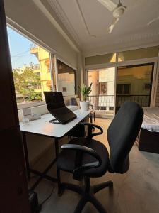 a desk with a laptop and a chair in a room at Gyan Kunj - House of Knowledge in Bengaluru