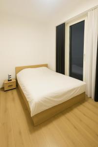 a bedroom with a large white bed and a window at Moonlight Panorama 27th Floor in Skopje