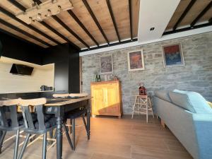 a living room with a table and a stone wall at STH1 - Cachette en centre-ville in Saint-Hubert