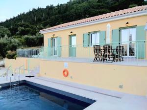 a villa with a swimming pool and a house at Phileo Villas in Platithriás
