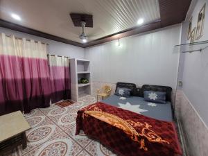 a room with a bed and a table in it at Radha Govind stays in Vrindāvan