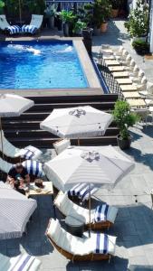 a group of chairs and umbrellas next to a swimming pool at Boutique 17B in Sibiu