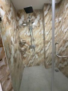 a shower in a bathroom with a stone wall at Dream Hotel in Hanoi